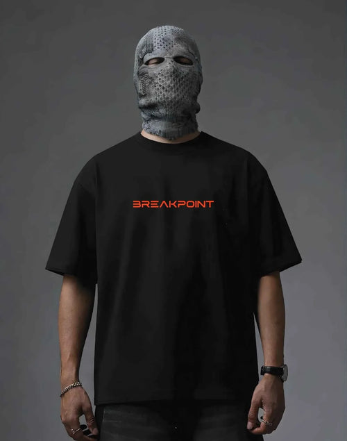 Black oversized t-shirt with red BREAKPOINT logo, worn with textured face mask for edgy streetwear style