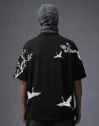 Black graphic tee with white crane and cherry blossom print, modern streetwear style